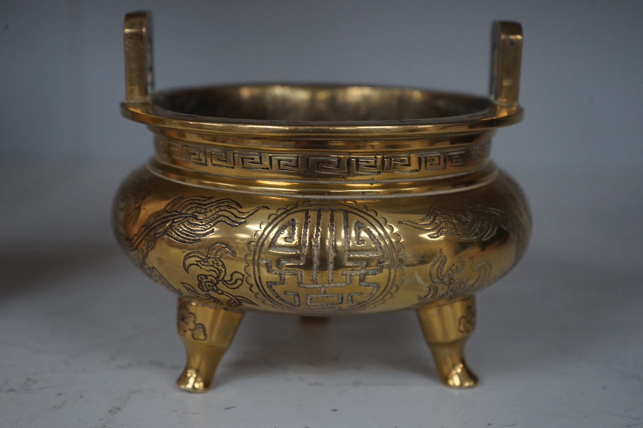 A Chinese engraved and chased bronze tripod censer, Xuande mark, early 20th century, 10.5cm. Condition - good